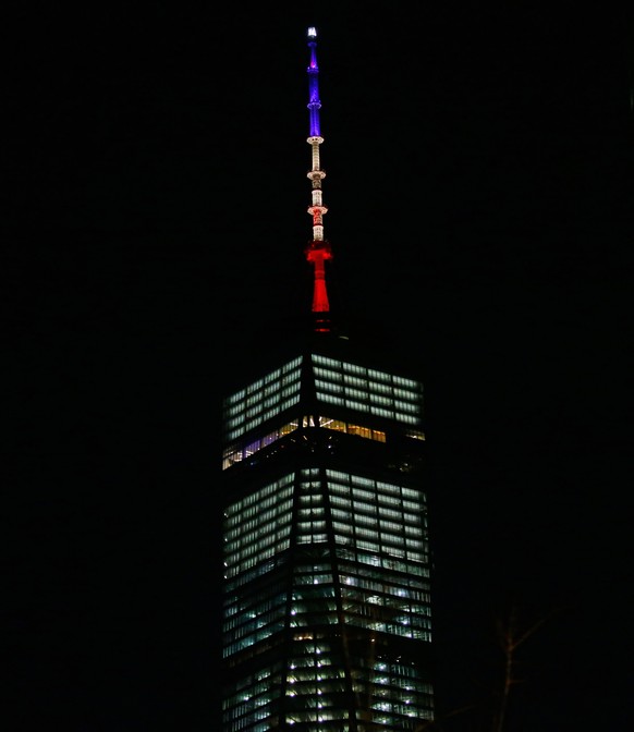 epa05226533 The spire of One World Trade center is illuminated in the colors of the French national flag, in New York, New York, USA, 22 March 2016. The spire was intended to be lit up in the colors o ...