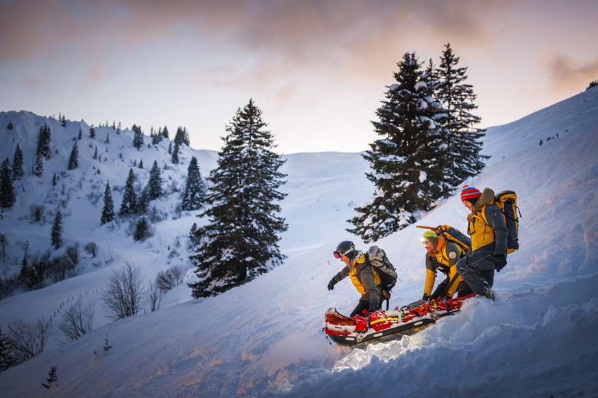 Des secouristes transportent un manequin sur un brancard lors d&#039;un exercice avalanche organise par les sauveteurs du Secours alpin romand (SARO) avec la participation entre autres de la Rega, des ...