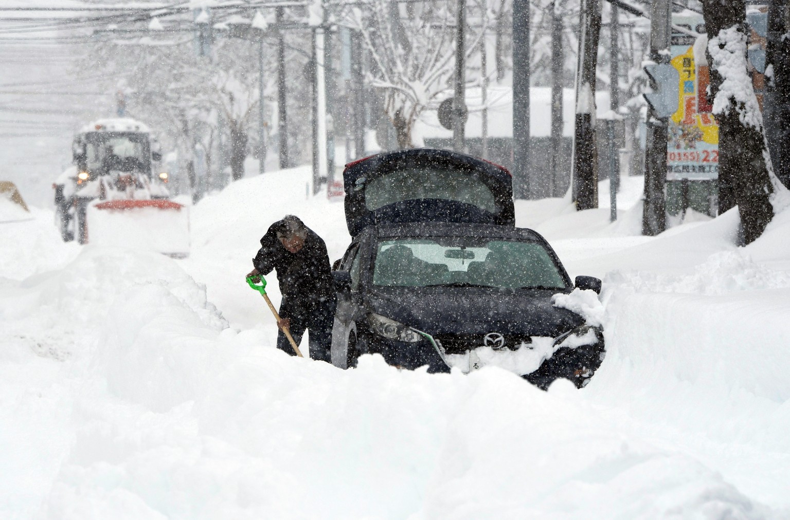 epa11875692 A man digs snow following heavy snowfall in Obihiro, Hokkaido, northern Japan, 04 February 2025 (issued 05 February 2025). On 05 February 2025, the coldest air of the winter persisted over ...