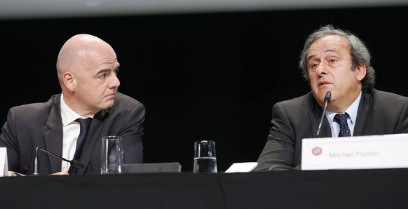 President of UEFA Michel Platini speaks during a press conference as UEFA Secretary General Gianni Infantino looks on following a meeting of the UEFA board ahead of the FIFA congress in a hotel in Zur ...