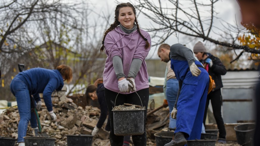 epa10273119 Volunteers carry baskets with the debris of a house, destroyed in combat action in Chernihiv, Ukraine, 29 October 2022. A group of local people from Chernihiv and the nearby village Novose ...