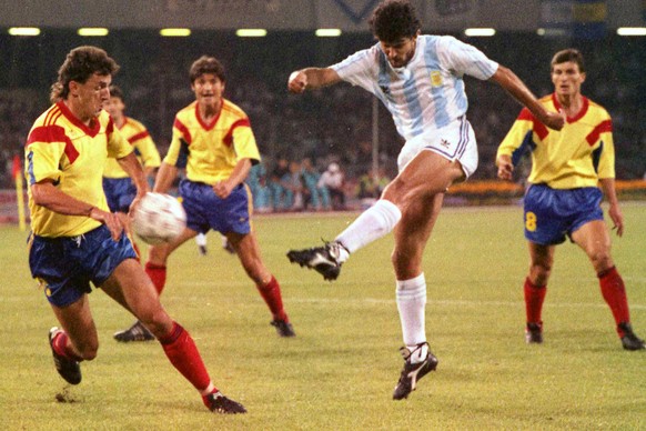 Argentina's Jorge Burruchaga shoots the ball past Romania's Gheorghe Popescu during the first minutes of the Soccer World Cup match between Argentina and Romania, in Naples, Italy, June 18, ...
