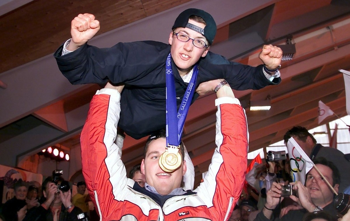 Auf den Haenden der Schwingerkoenige Noeldi Forrer und Joerg Abderhalden, hinten verdeckt, fliegt der Doppelolympiasieger Simon Ammann am Sonntag, 24. Februar 2002 in die Festhalle in Unterwasser ein. ...