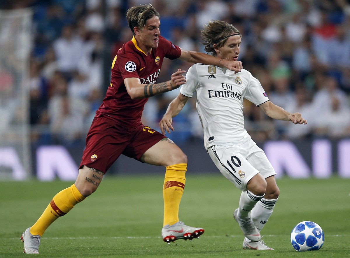 Real midfielder Luka Modric, right, duels for the ball with Roma midfielder Nicolo' Zaniolo during a Group G Champions League soccer match between Real Madrid and Roma at the Santiago Bernabeu st ...