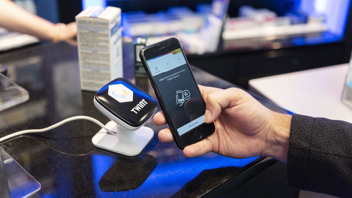 [Staged Picture] A person uses the Twint cashless payment system via app on a smartphone at a Twint beacon terminal in an Amavita pharmacy in Berne, Switzerland, on May 2, 2018. (KEYSTONE/Christian Be ...