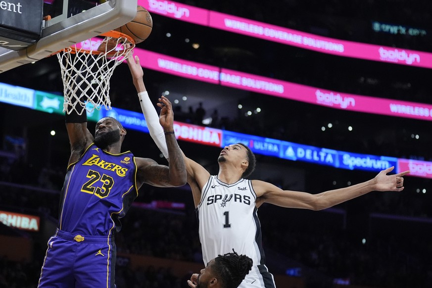 Los Angeles Lakers forward LeBron James (23) vies for a rebound against San Antonio Spurs center Victor Wembanyama (1) during the first half of an NBA basketball game Friday, Feb. 23, 2024, in Los Ang ...