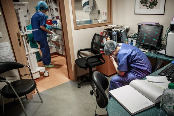 epa08758510 YEARENDER 2020 .COVID-19 PANDEMIC..A tired nurse at the surveillance post during a night watch at the resuscitation intensive care unit of the Ambroise Pare clinic in Neuilly-sur-Seine, ne ...