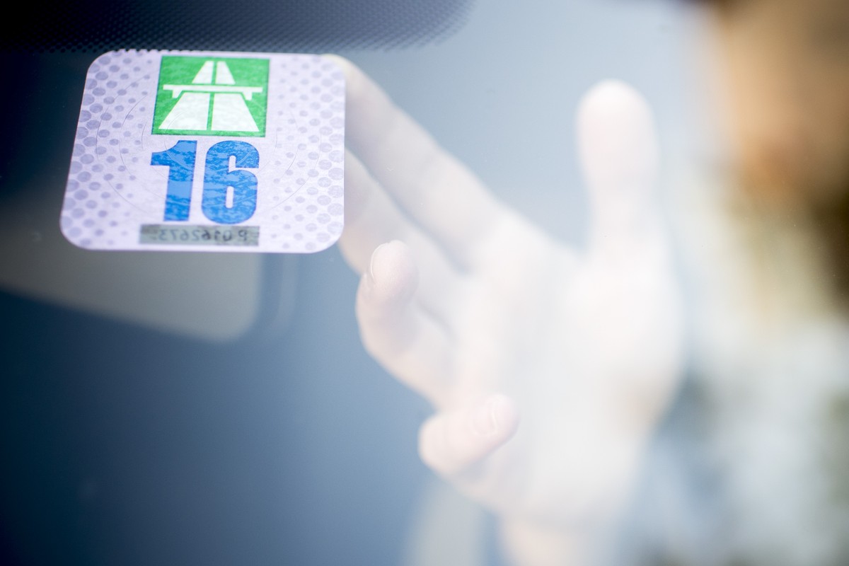 ARCHIV --- ZUM PILOTPROJEKT MOBILITY-PRICING STELLEN WIR IHNEN FOLGENDES BILD ZUR VERFUEGUNG --- Eine Frau klebt die Autobahnvignette fuer das Jahr 2016 an die Frontscheibe ihres Autos, am Dienstag, 2 ...