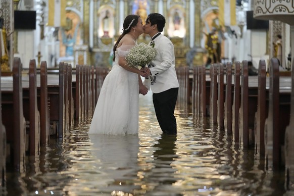 Newlyweds Jade Rick Verdillo right, and Jamaica kiss during their wedding at the flooded Barasoain church in Malolos, Bulacan province, Philippines on Tuesday, July 22, 2025. (AP Photo/Aaron Favila)
P ...