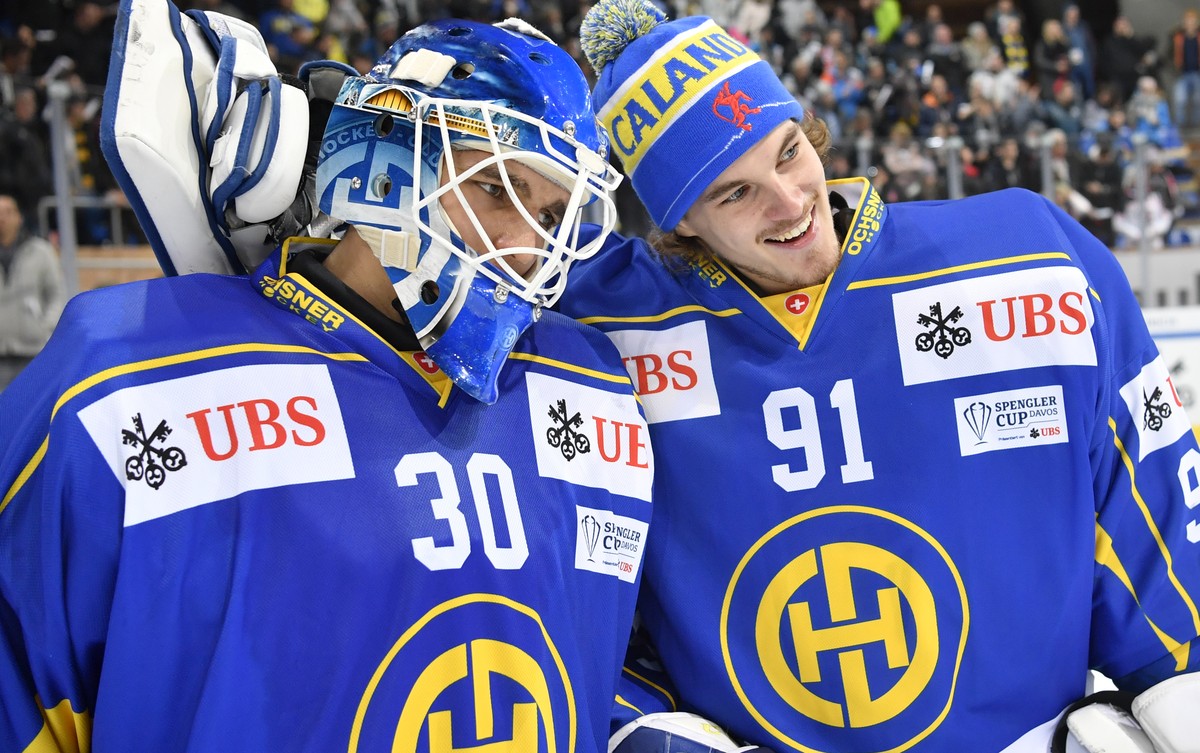 Davos' Joren van Pottelberghe, left, and goalkeeper Gilles Senn celebrate after winning the game between HC Davos and Mountfield HK at the 91th Spengler Cup ice hockey tournament in Davos, Switze ...