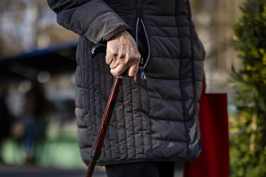 Eine aeltere Frau geht mit einer Gehhilfe durch den Wochenmarkt auf dem Buerkliplatz, am Dienstag, 13. Februar 2024 in Zuerich. Die Zuercher Stadthausanlage wird ab September 2024 erneuert. Deshalb mu ...