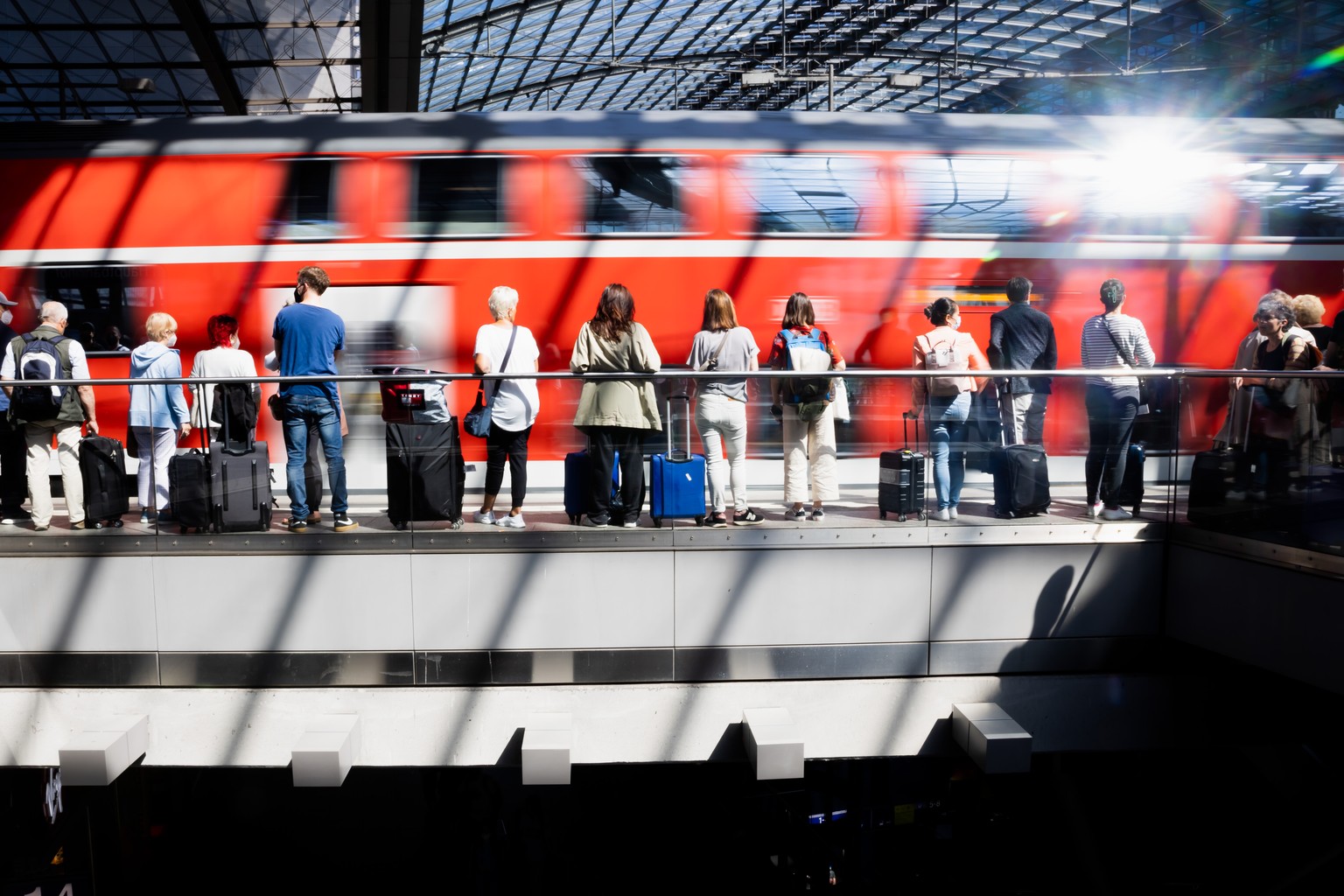 05.06.2022, Berlin: Fahrg�ste warten am Berliner Hauptbahnhof am Gleis, als ein Regionalexpress einf�hrt. Durch das 9-Euro-Ticket wird mit mehr Verkehr am Pfingstwochenende gerechnet, das in vielen Bu ...