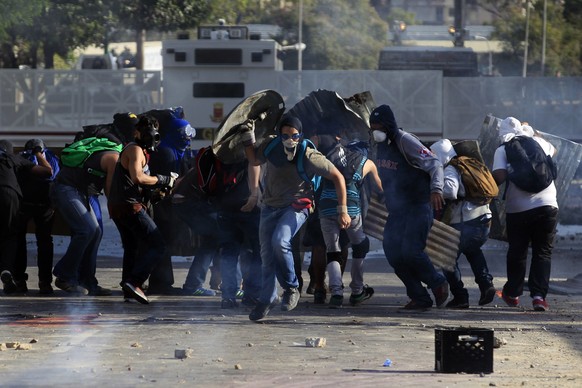Anti-government protesters run from the national guard at Altamira square in Caracas March 4, 2014. Venezuela geared up on Tuesday for commemorations of socialist leader Hugo Chavez's death despite continued protests against his successor that have shaken the OPEC member and threatened the legacy of "El Comandante."  REUTERS/Tomas Bravo (VENEZUELA - Tags: POLITICS CIVIL UNREST)
