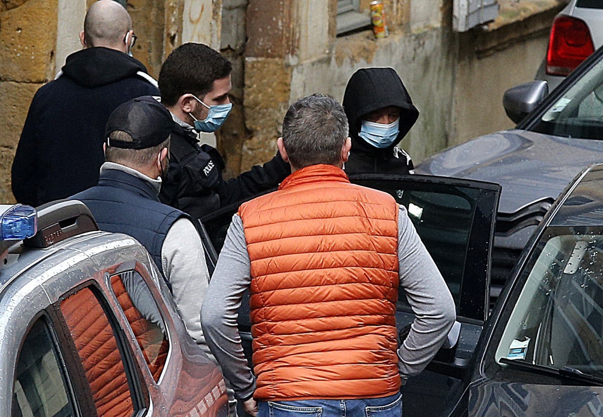 (FILES) A suspect (R) flanked by French judicial police officers, exits a building after attending a reconstruction of the sequence of events, at the scene where the body of 10-year-old Loana was foun ...