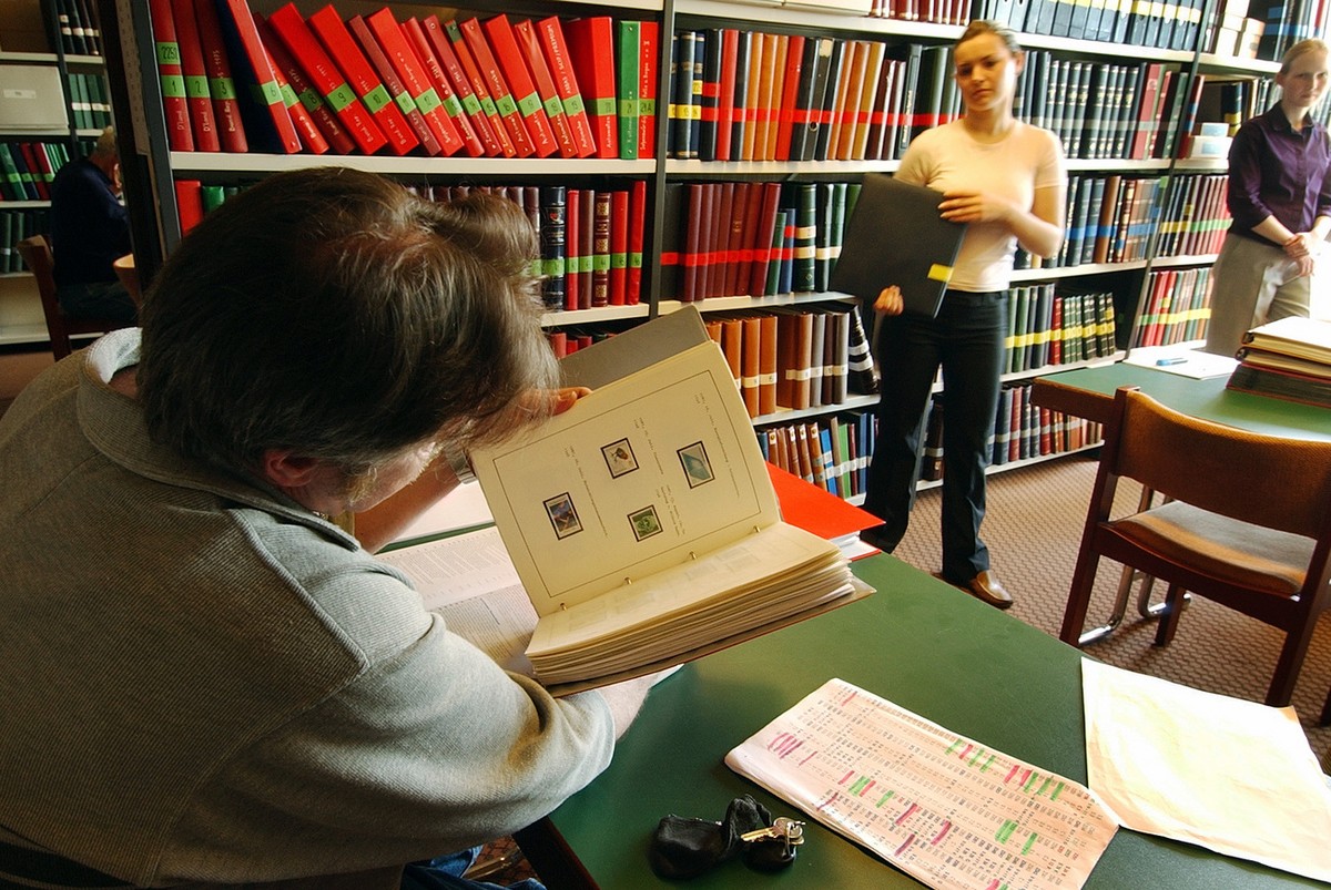 Ein Briefmarkensammler begutachtet im Vorfeld der Auktion einen der vielen Tausend Alben auf Qualitaet und Zustand der Marken, aufgenommen am Mittwoch, 12. Mai 2004, anlaesslich der Briefmarkenauktion ...