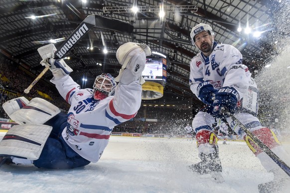 Zuerichs Torhueter Lukas Flueeler, links, und Zuerichs Patrick Geering in Aktion, im fuenften Eishockey Playoff-Halbfinalspiel der National League zwischen dem SC Bern und den ZSC Lions, am Donnerstag ...