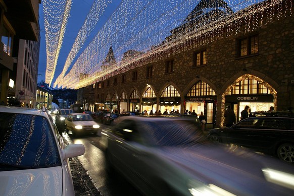 Abendstimmung mit flanierenden Fussgaengern und dem Strassenverkehr in der Via Serlas von St. Moritz, aufgenommen am 4. Januar 2003. Im mondaenen Engadiner Hoehenort finden sich die Nobelgeschaefte vi ...