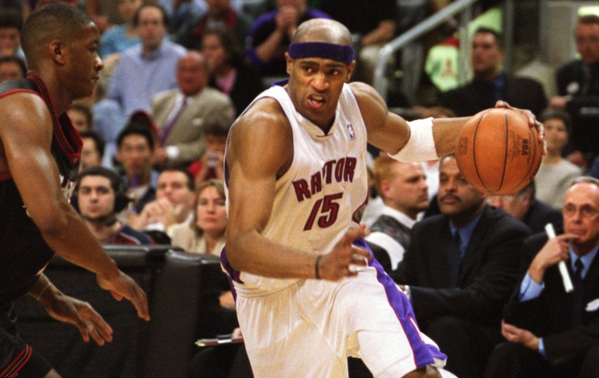 Toronto Raptor Vince Carter with ball, tries to go around Philadelphia 76er Eric Snow, in the fourth quarter of game four of the NBA Eastern Conference semifinal, played in Toronto, May 13, 2001. The  ...
