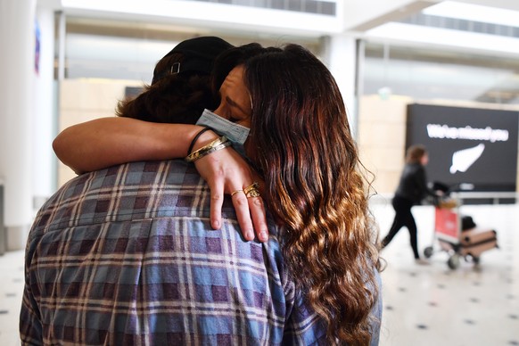 epa08749191 Taren Kowalski (R) is welcomed home by her boyfriend Jayden Guest (L) as she arrives from New Zealand, at Sydney International Airport in Sydney, Australia, 16 October 2020. Australia&#039 ...