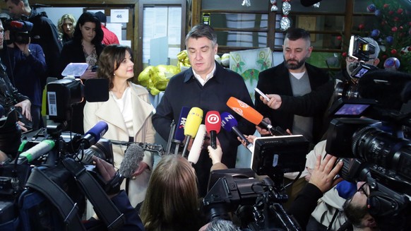 epa08086563 Croatian presidential candidate of Social Democratic Party (SDP) Zoran Milanovic (C) makes a statement after he casted his vote at a polling station in Zagreb, Croatia, 22 December 2019. C ...