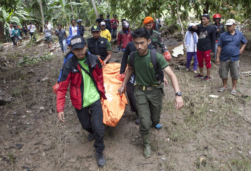 epa07247340 Indonesian volunteers carry a body after a tsunami on Anyer Beach in Karang Sugara village, Anyer, Banten, Indonesia, 24 December 2018. According to the Indonesian National Board for Disas ...