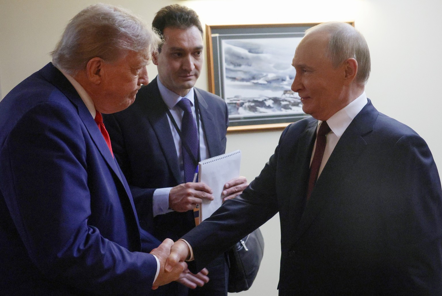 epa12303726 US President Donald Trump (L) and Russian President Vladimir Putin (R) shake hands before a joint news conference following their meeting at Joint Base Elmendorf-Richardson in Anchorage, A ...