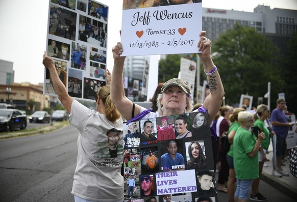 Lynn Wencus of Wrentham, Mass. holds a sign for her son Jeff along with wearing a sign of other&#039;s loved ones lost to OxyContin and Opioid overdoses during a protest at Purdue Pharma LLP headquart ...