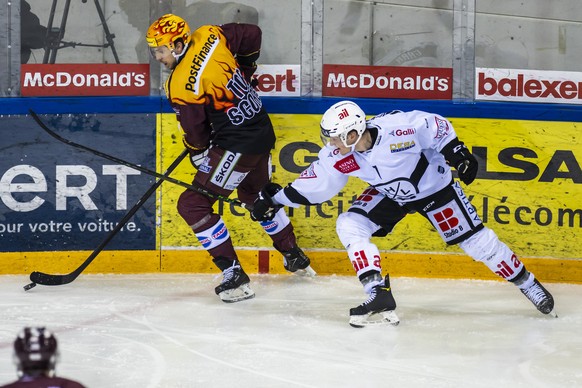 Le top scorer PostFinance genevois Henrik Toemmernes, gauche, a la lutte pour le puck avec l&#039;attaquant luganais Daniel Carr, droite, lors du match des Pre-PlayOffs du championnat suisse de hockey ...