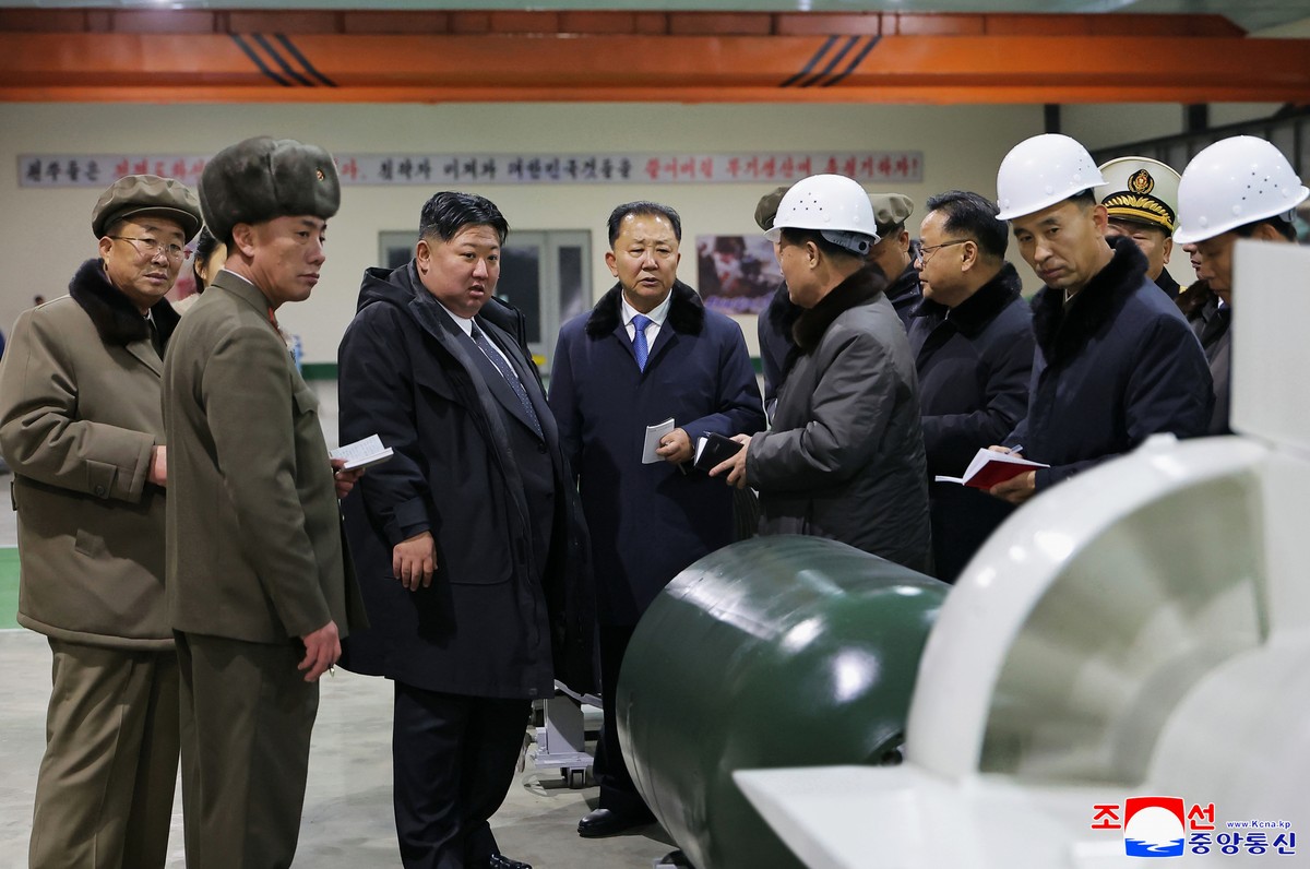 In this undated photo provided Thursday, Dec. 25, 2025, by the North Korean government, its leader Kim Jong Un, third left, visits a shipyard as he inspects a nuclear-powered submarine under construct ...