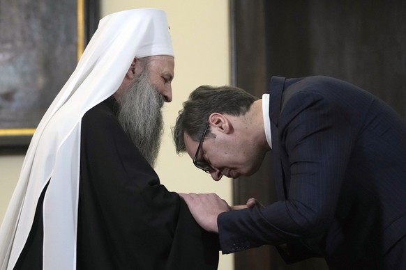 Serbian President Aleksandar Vucic, right, kisses the hand of Serbian Orthodox Church Patriarch Porfirije after a press conference following talks in Belgrade, Serbia, Tuesday, Dec. 27, 2022. Tensions ...