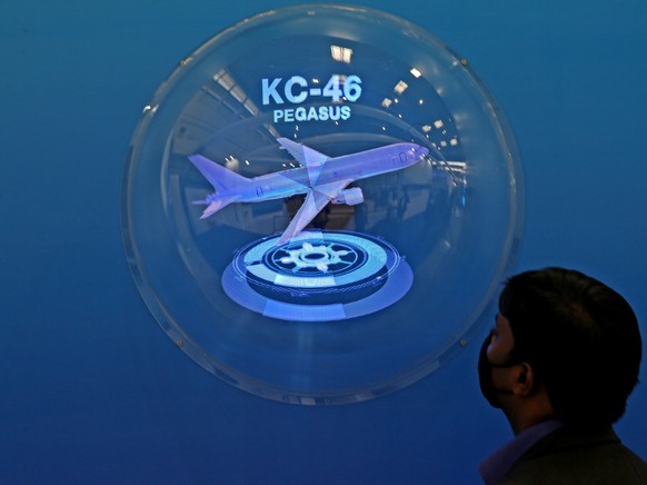 epa08986308 A visitor looks at an image display of the Boeing KC-46 Pegasus military aerial refueling and strategic aircraft on day two of the 13th Aero India 2021 at Yelahanka Air Force Station in Ba ...