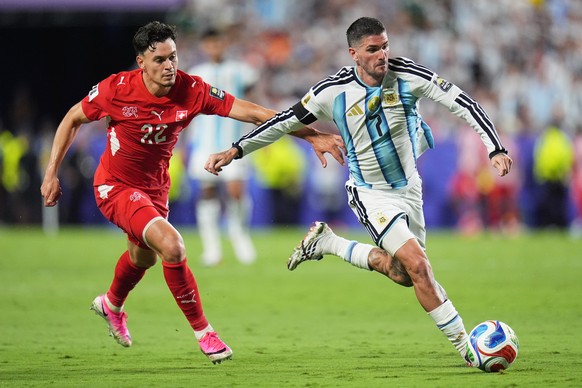 Argentina's Rodrigo de Paul, right, controls a ball chased by Switzerland's Fabian Rieder during the World Cup quarterfinal soccer match in Kansas City, Mo., Saturday, July 11, 2026. (AP Pho ...