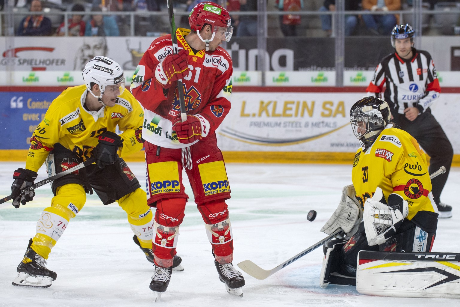 Biels Michael Huegli, Mitte, kaempft um den Puck gegen Berns Thomas Thiry, links, und Goalie Philip Wuethrich, rechts, waehrend dem Qualifikationsspiel der National League zwischen dem EHC Biel und de ...