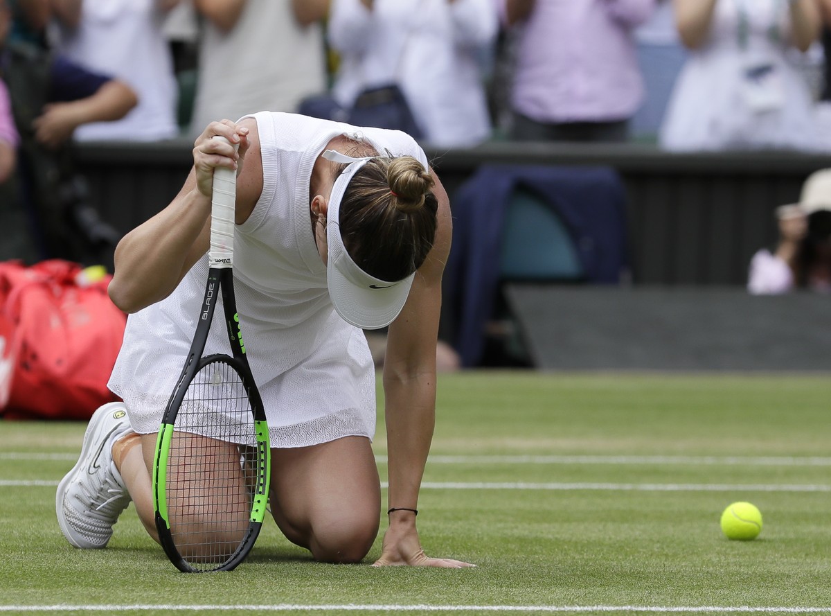 Romania's Simona Halep kneels on the court after defeating United States' Serena Williams during the women's singles final match on day twelve of the Wimbledon Tennis Championships in L ...