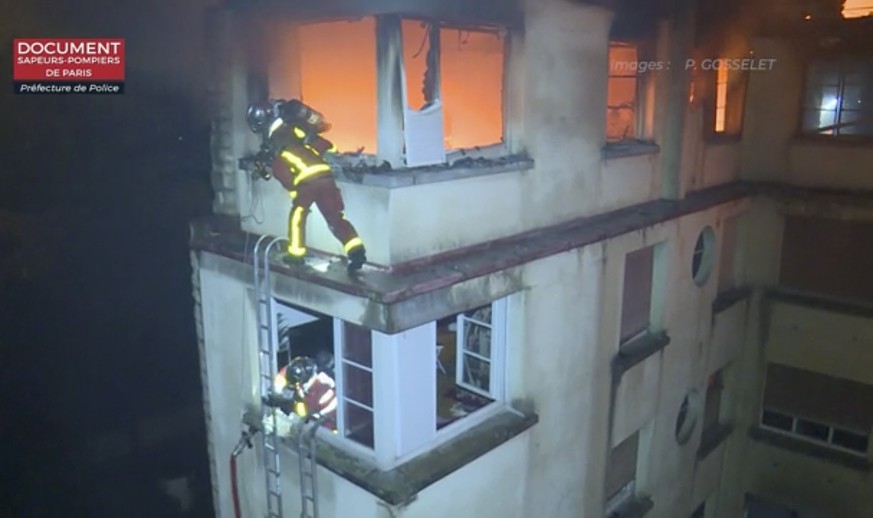 In this image taken from video released by the Paris Fire Dept., firemen scale the top floors of an apartment building on fire, Tuesday, Feb. 5, 2019, in Paris, France. A fire in a Paris apartment bui ...