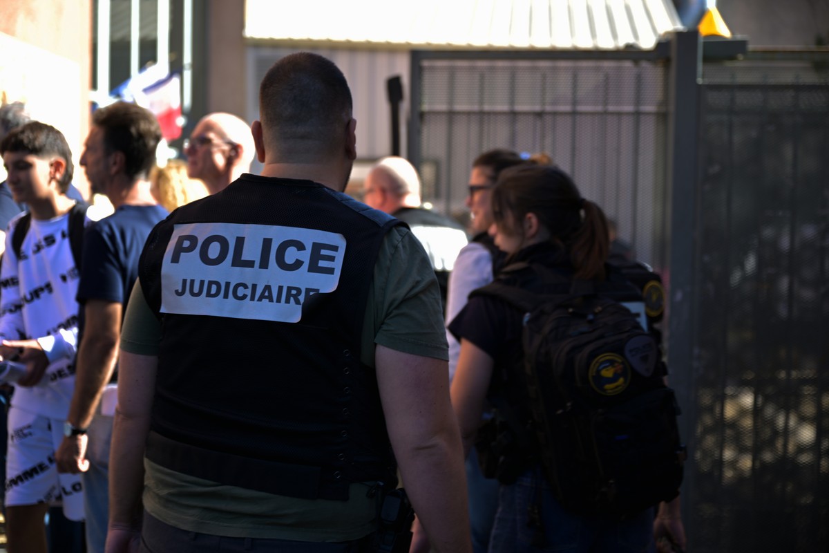 A police officer stands in front the Joseph Lakanal middle school after police have detained a 14-year-old pupil suspected in a rare school shooting, in Aubagne, France, Monday Oct. 12, 2026. (AP Phot ...