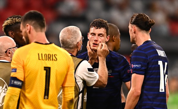 epa09274712 Benjamin Pavard (C-R) of France receives medical assistance during the UEFA EURO 2020 group F preliminary round soccer match between France and Germany in Munich, Germany, 15 June 2021. EP ...