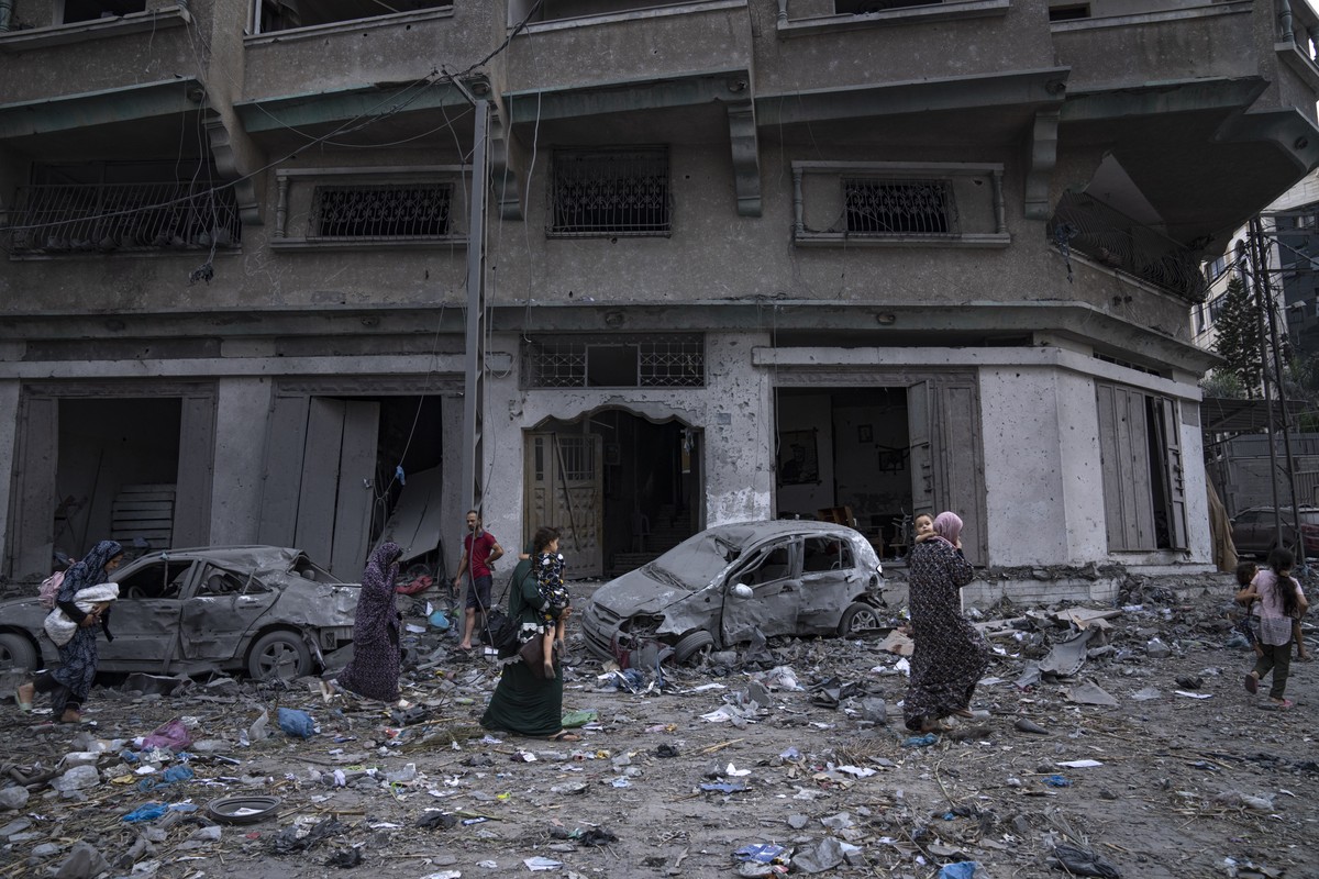 Palestinians walk amid the rubble following Israeli airstrikes that razed swaths of a neighborhood in Gaza City, Tuesday, Oct. 10, 2023. The militant Hamas rulers of the Gaza Strip carried out an unpr ...