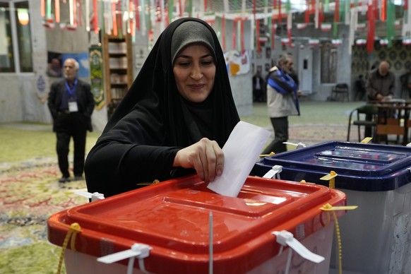 A woman casts her vote during the elections for the Parliament and the Assembly of Experts at a polling station in Tehran, Iran, Friday, March 1, 2024. Iran held the country's first elections since...