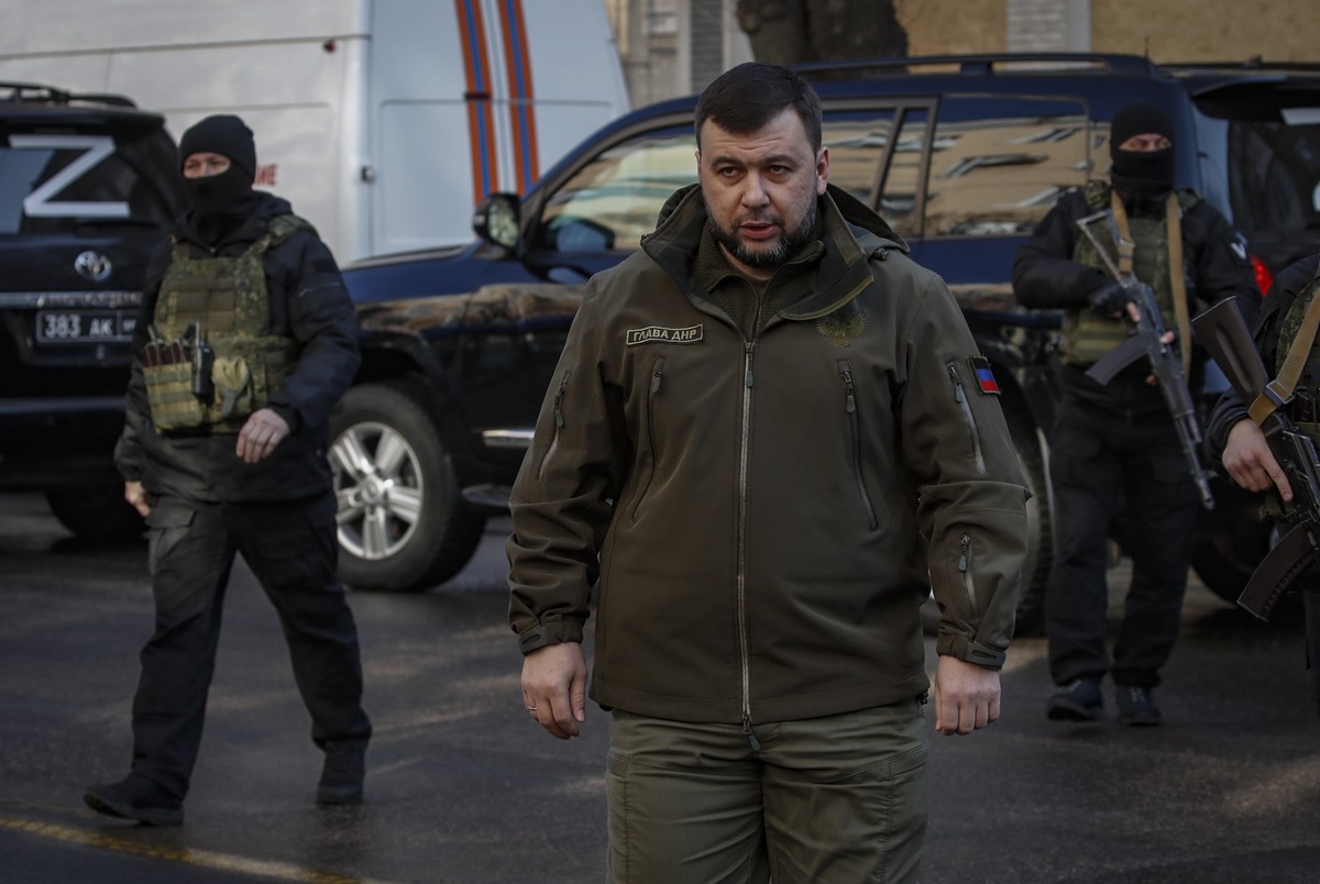 epa09852015 Head of the Donetsk People's Republic Denis Pushilin (C) walks in downtown of Donetsk, Ukraine, 26 March 2022. On 14 March over the building of the Government House in the center of D ...