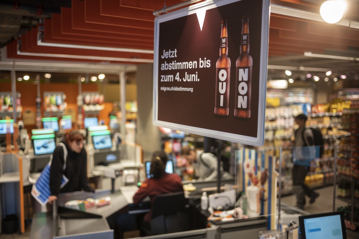 Plakate weisen auf die Abstimmung zum moeglichen Verkauf von alkoholischen Getraenken in der Migros hin, am Dienstag, 24. Mai 2022 in der Migros Filiale Lorraine in Bern. Anfang Juni 2022 koennen die  ...
