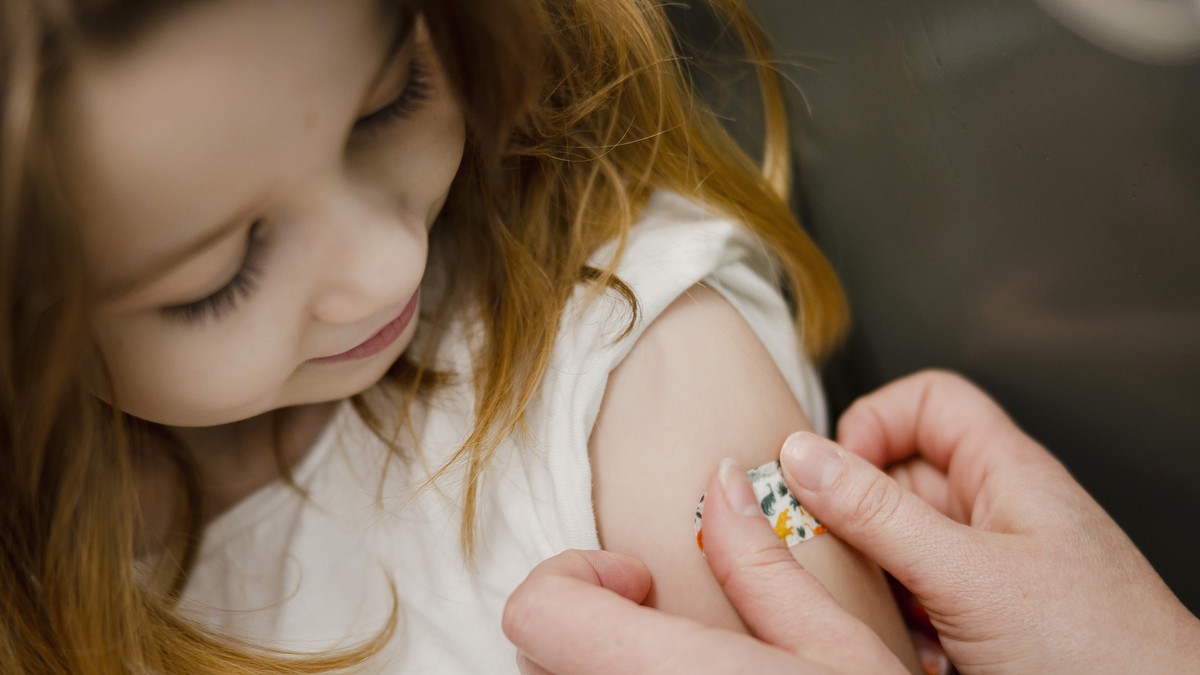 Eine Pflegefachfrau HF, klebt der 5 Jahre alten Lorena nach der Covid-19 Impfung ein Pflaster auf den Arm, im Referenz-Impfzentrum des Kantons Zuerich beim Zentrum f