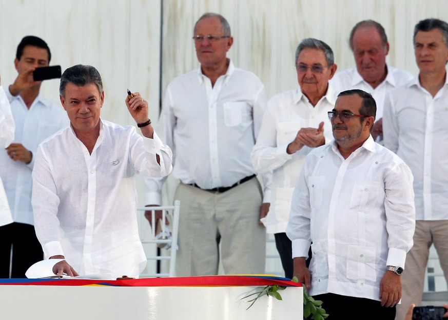 Der kolumbianische Präsident&nbsp;Juan Manuel Santos (links) und FARC-Kommandeur Rodrigo Londoño unterzeichnen den historischen Vertrag.