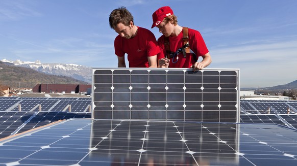 ZUM THEMA ENERGIESTRATEGIE 2050 STELLEN WIR IHNEN FOLGENDES BILDMATERIAL ZUR VERFUEGUNG - Employees of the &quot;energiebuero ag&quot; Zurich are mounting solar panels for a solar power plant on the r ...