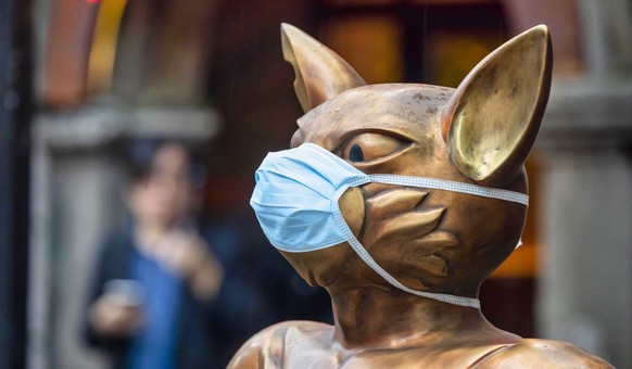 epa08669477 A statue of a cat is decorated with a protective face mask, in the financial district of Shanghai, China, 14 September 2020 (issued 15 September 2020). China&#039;s value-added industrial  ...