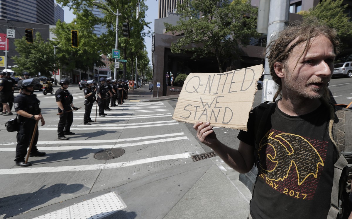In this Aug. 18, 2018 file photo man holds a sign that reads "Q-Nited We Stand" during a rally held by members of Patriot Prayer and other groups supporting gun rights near City Hall in Seat ...