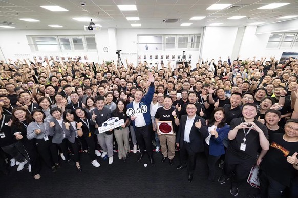 epa10666595 A handout photo made available by Tesla, Inc. shows Tesla CEO Elon Musk (front C) posing for a group photo with his employees at the auto maker&#039;s Shanghai factory, in Shanghai, China, ...