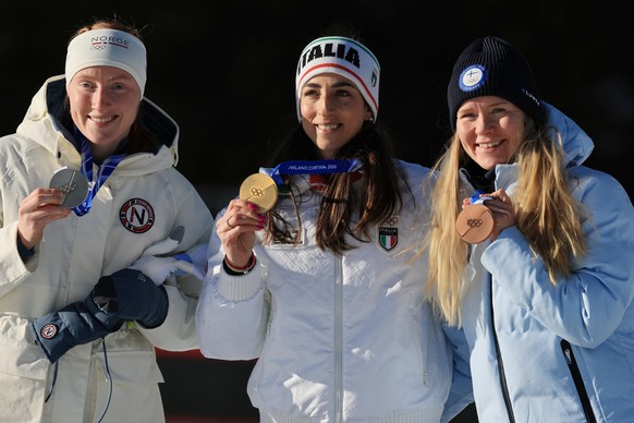 epa12743356 (L-R) Silver medalist Maren Kirkeeide of Norway, gold medalist Lisa Vittozzi of Italy and bronze medalist Suvi Minkkinen of Finland react during the award ceremony for the Women's 10k ...