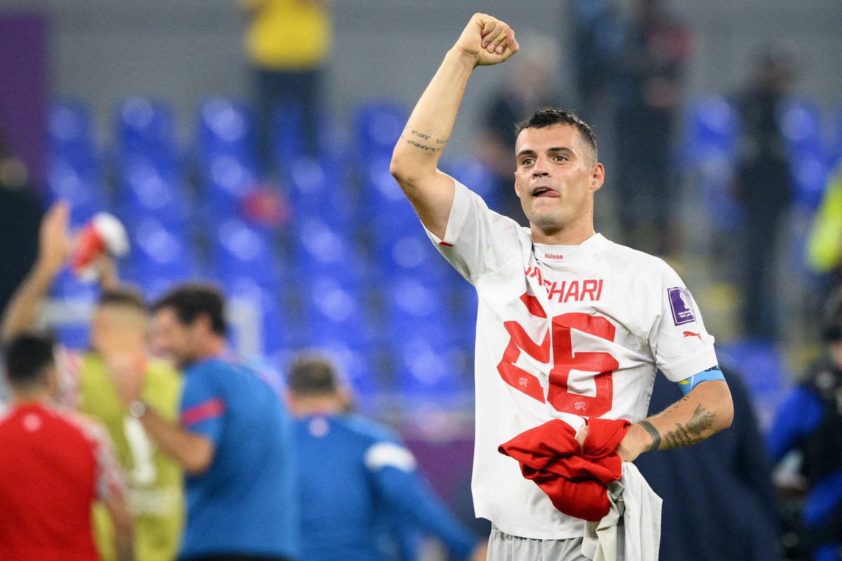Switzerland's midfielder Granit Xhaka celebrates the victory and the qualification with the shirt of Switzerland's midfielder Ardon Jashari after the FIFA World Cup Qatar 2022 group G soccer ...