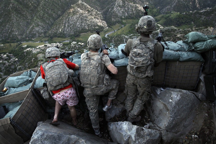 Soldiers from the U.S. Army First Battalion, 26th Infantry take defensive positions at firebase Restrepo after receiving fire from Taliban positions in the Korengal Valley of Afghanistan&#039;s Kunar  ...